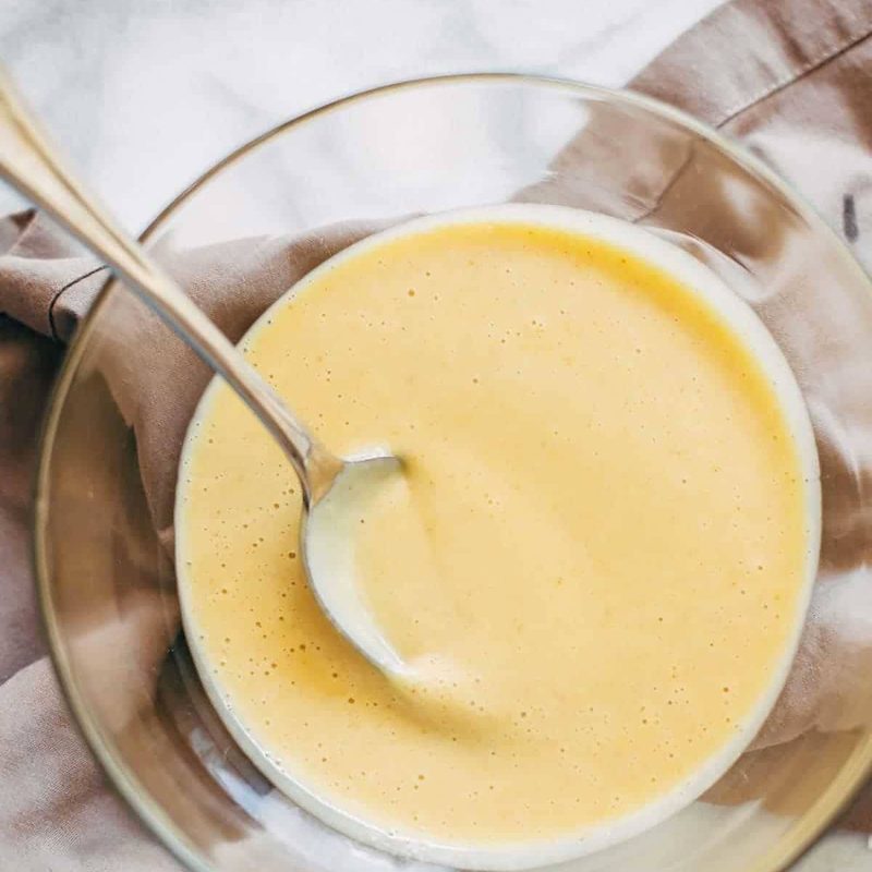 Honey mustard sauce in a bowl with a spoon.