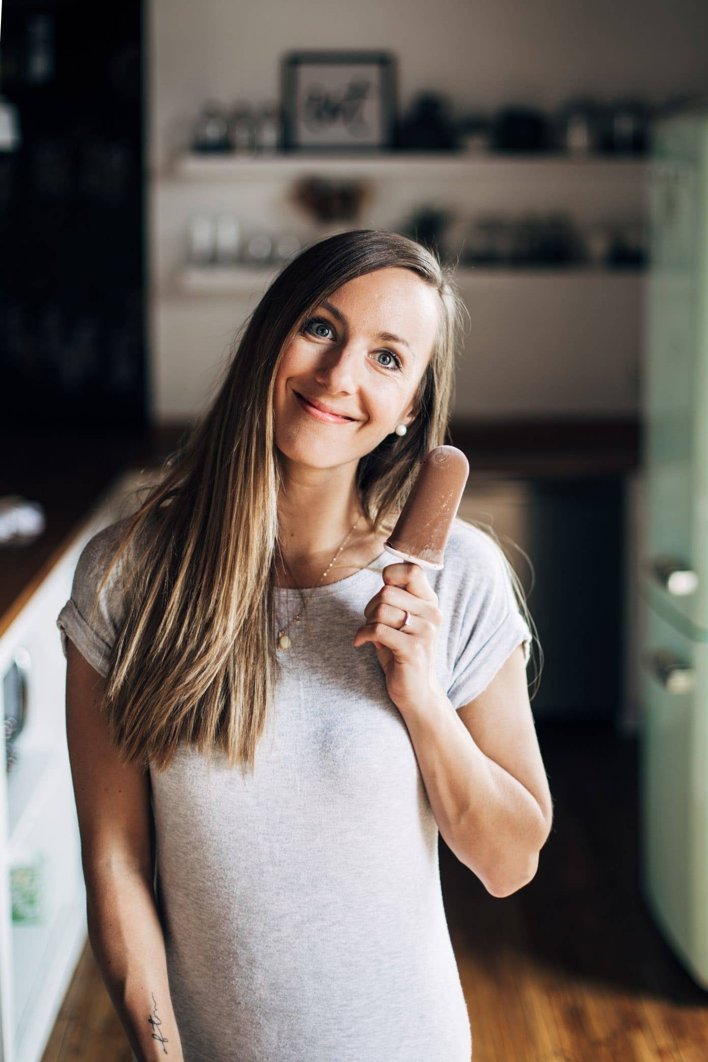 Lindsay holds a frozen chocolate popcicle in one hand.